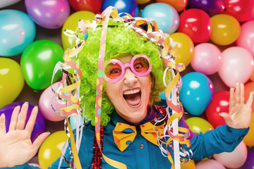 Obraz na płótnie Canvas Frau in Karnevalstimmung auf einem bunten Hintergrund aus Luftballons 