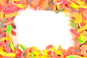 Frame of assorted gummy candies isolated on white. Top view. Space for text or design.
