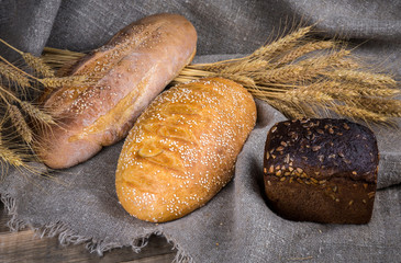 Fresh fragrant bread on a wooden table. Homemade hot pastry with.