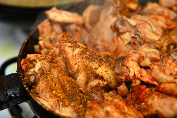 Fried chicken with spices in a pan