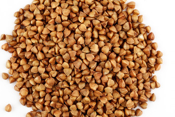 Pile of raw buckwheat seeds on a white background