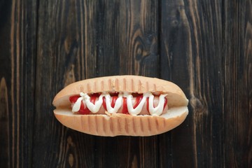 hot dog with sauce and mustard on wooden background.photo with copy space