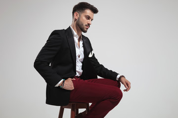 side view of seated smart casual man looking down