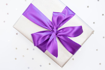 Beauty box-gift in paper with trendy violet ribbon and bow-knot and sprickle silver stars. Holiday concept.