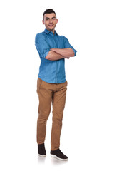 young casual man standing with folded hands