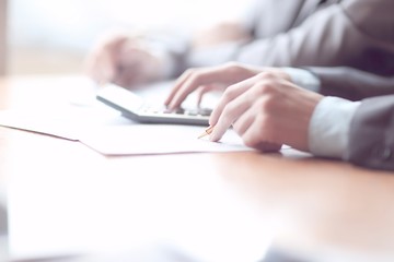 Close up of businessman or accountant hand holding pencil working on calculator to calculate financial data report,