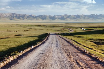Fototapeta na wymiar Unpaved road and yurts near Son-Kul lake in Kyrgyzstan