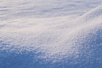 Fresh shiny snow on the ground and snowdrift on a sunny day, good as a winter season background.