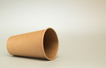 empty paper cup for coffee lies on its side on white background