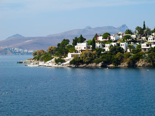 Marvelous blue water Aegean coast with rich nature, mountains and small white houses