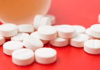 Fototapeta na wymiar painkiller pills close up on red background