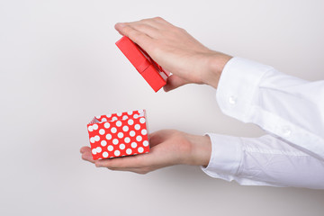 Side profile close up photo portrait of hands holding open unpack unwrap present box in hands isolated grey background