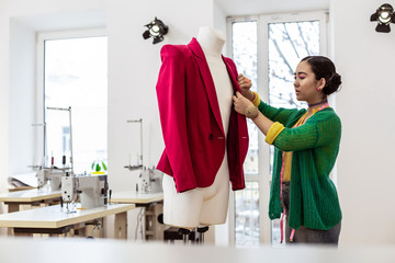 Obraz premium Cute asian dark-haired dressmaker with bright makeup looking serious