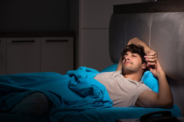 Fototapeta premium Tired exhausted man sleeping in his bed