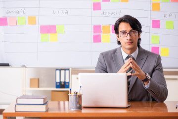 Young handsome employee working in the office