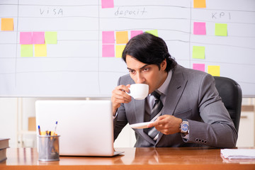 Young handsome employee working in the office