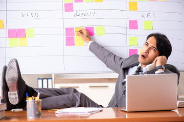 Young handsome employee working in the office