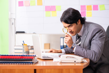 Young handsome employee working in the office