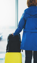 traveler tourist suitcase backpack at airport on background large window, girl in departure lounge area hall of ​ airport lobby terminal, vacation trip concept, empty space mockup