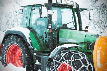 Tractor cleaning snow in field. Close up view of a tractor. Cleanining winter truck in the village.