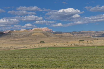 green farming lands in Tropic valley surrounded by sandstone buttes of Backbone Ridge (Garfield county, Utah)