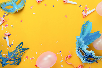 Tischplattenansicht Luftbild des schönen bunten Karnevals-Festival-Hintergrunds. Flaches Zubehörobjekt, das Masken- und Dekorkonfetti und der Ballon auf modernem gelbem Papier im Home-Office-Schreibtischstudio.