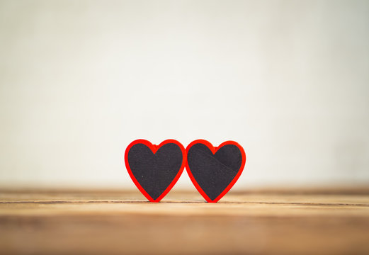 Conceptual image of couple of hearts together on vintage wooden table for love and Valentines day