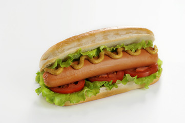 Hotdog on a white background. Hotdog stuffing consists of sausage, lettuce, tomato slices, mustard and ketchup. Close-up. Macro shooting.