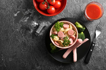 Delicious pasta with sausage in bowl on grey table