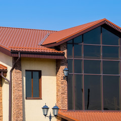 building with yellow walls and a red-brown roof. Modern material