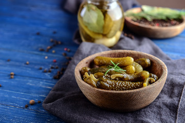 Plate with tasty fermented cucumbers on wooden table