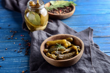 Plate with tasty fermented cucumbers on wooden table