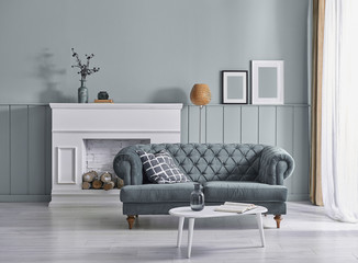 Black and white room, white fireplace and sofa, orange lamp and frame decor.