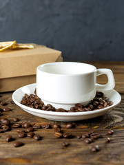 Coffee cup and beans on old kitchen table.