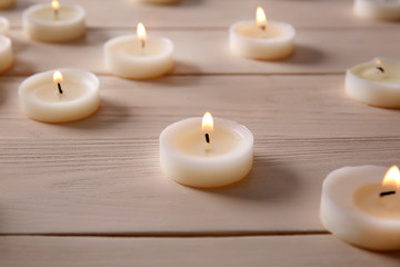 Fototapeta na wymiar Many burning candles on wooden table