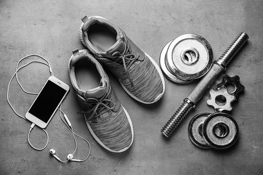 Shoes, sport equipment and mobile phone on grey background
