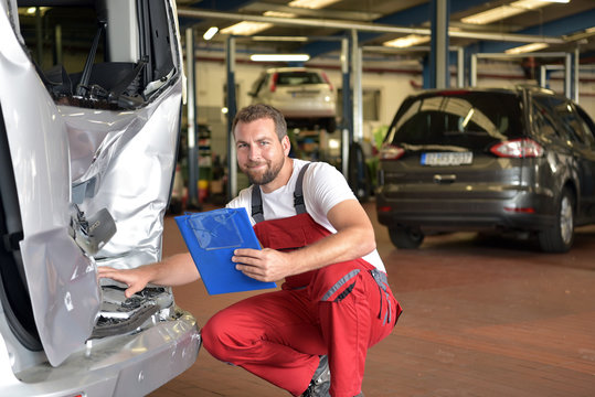 Gutachten bei kaputten Unfallwagen in einer Autowerkstatt nach Verkehrsunfall