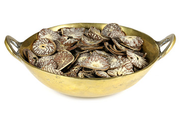 sliced betel nuts in a brass bowl isolated on white background
