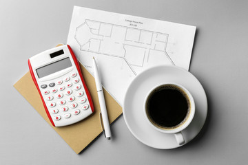 Project of house, calculator, notebook and cup of coffee on grey background. Mortgage concept