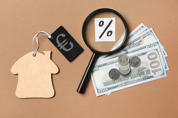 Figure of house, money and magnifier on color background. Mortgage concept