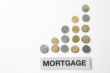 Coins and word MORTGAGE on white background