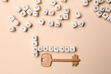 Words HOME and MORTGAGE composed of cubes and key on color background