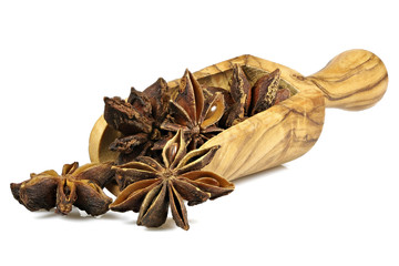 star anise in a scoop made of olive wood isolated on white background