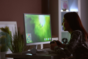 Fototapeta na wymiar Beautiful young woman playing computer game at home