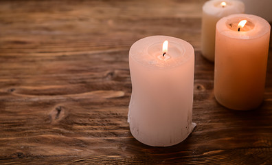 Obraz na płótnie Canvas Burning wax candles on wooden table