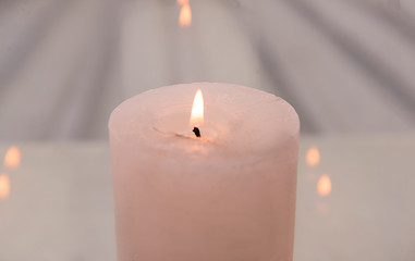Fototapeta na wymiar Burning wax candle on light background, closeup