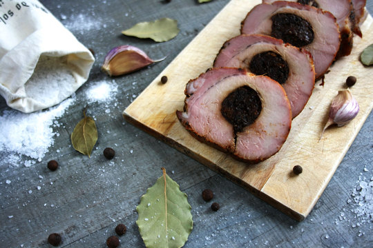 Pieczony schab ze śliwką pokrojony w plastry otoczony przyprawami