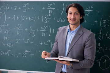 Young handsome math teacher in classroom 