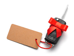 Gift Car keys with remote control alarm with red ribbon with bow and label. Isolated On White...