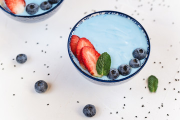 Blue yogurt smoothie made with blue spirulina powder, strawberries and blueberries.